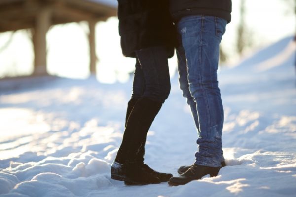 雪の上で向き合うカップル
